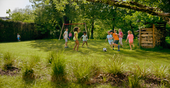 Children playing soccer in backyard