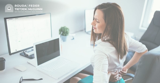 woman with hurt back sitting in chair